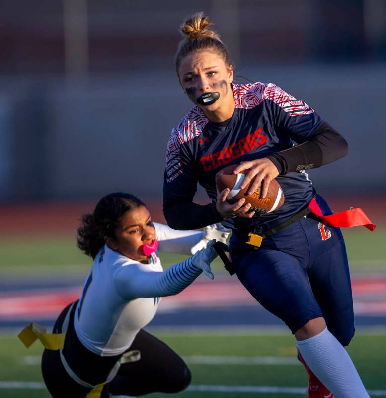 Coronado quarterback Bailey Goldberg (1) looks to evade a stop by Sierra Vista defender Lydia M ...