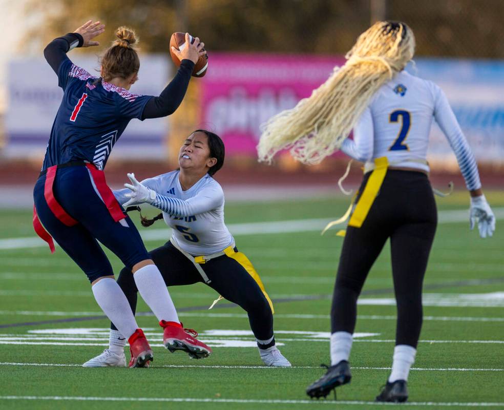 Coronado quarterback Bailey Goldberg (1) looks to evade a stop by Sierra Vista defender Amaya A ...