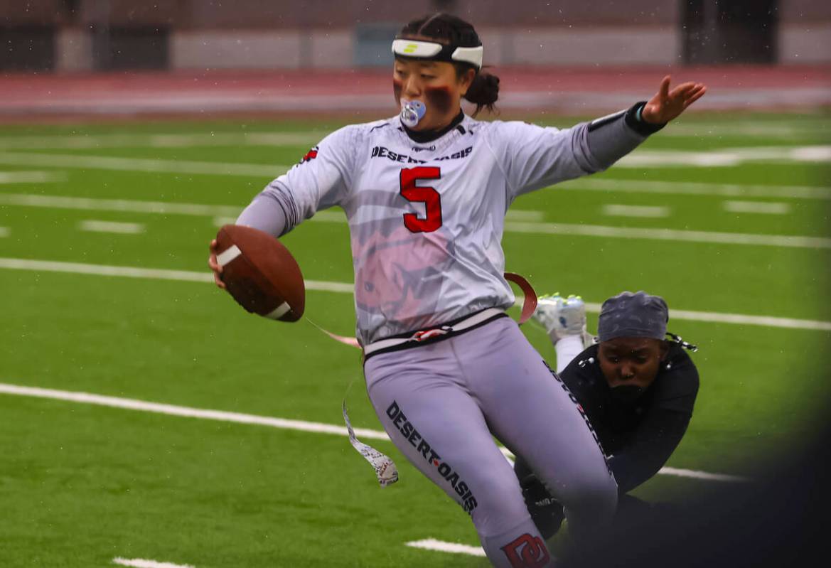 Desert Oasis quarterback Akemi Higa (5) dodges a Shadow Ridge defender while running the ball d ...