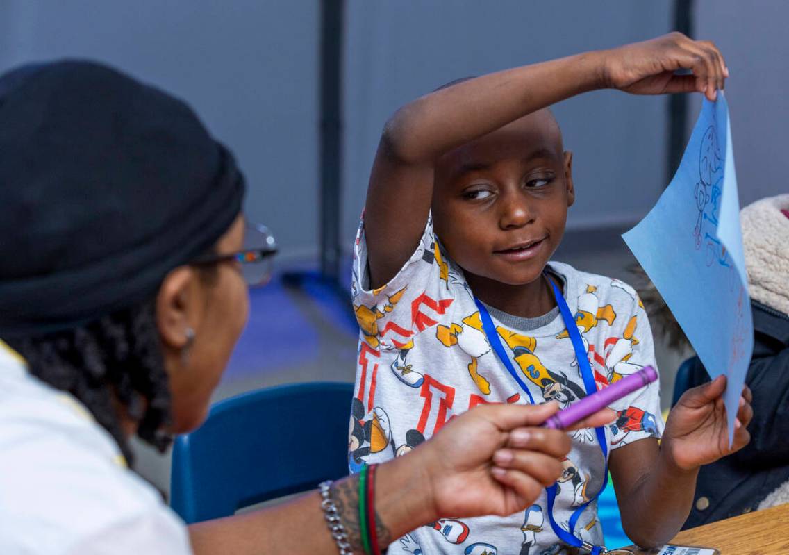 First grade student Naeshun Sanders shows off his drawing to Southern Nevada Black Educators In ...