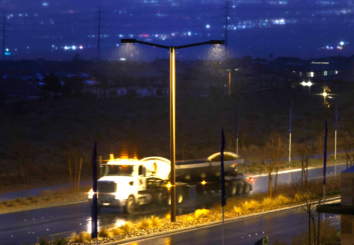A truck drives past under a streetlights as rain continues to fall on Lake Mead Parkway, on Thu ...
