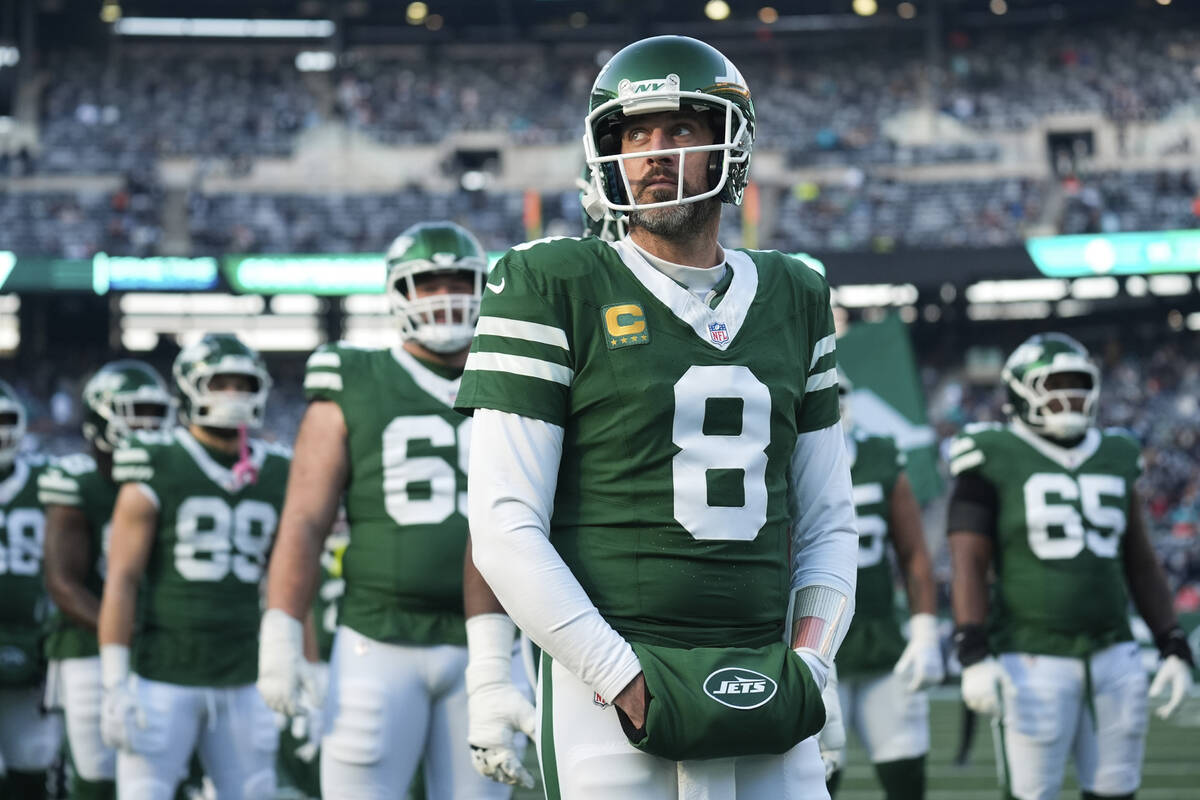 New York Jets quarterback Aaron Rodgers (8) stands with teammates before an NFL football game a ...