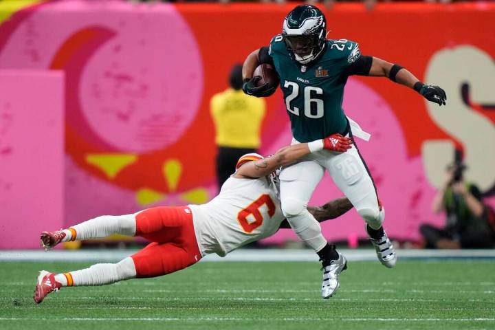 Philadelphia Eagles running back Saquon Barkley (26) tries to elude the tackle of Kansas City C ...