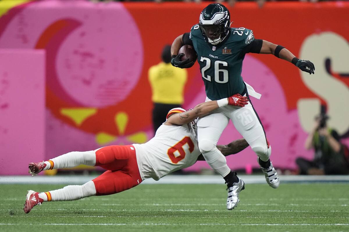 Philadelphia Eagles running back Saquon Barkley (26) tries to elude the tackle of Kansas City C ...