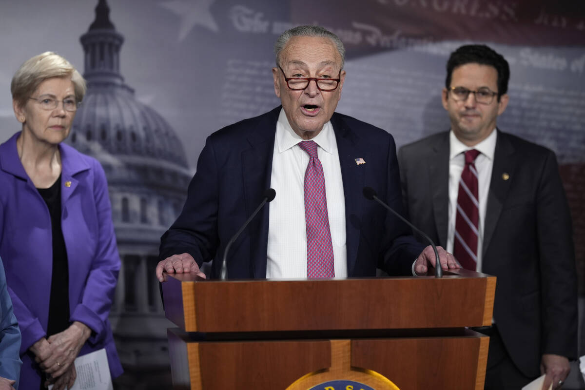 Senate Minority Leader Chuck Schumer, D-N.Y., center, flanked by Sen. Elizabeth Warren, D-Mass. ...