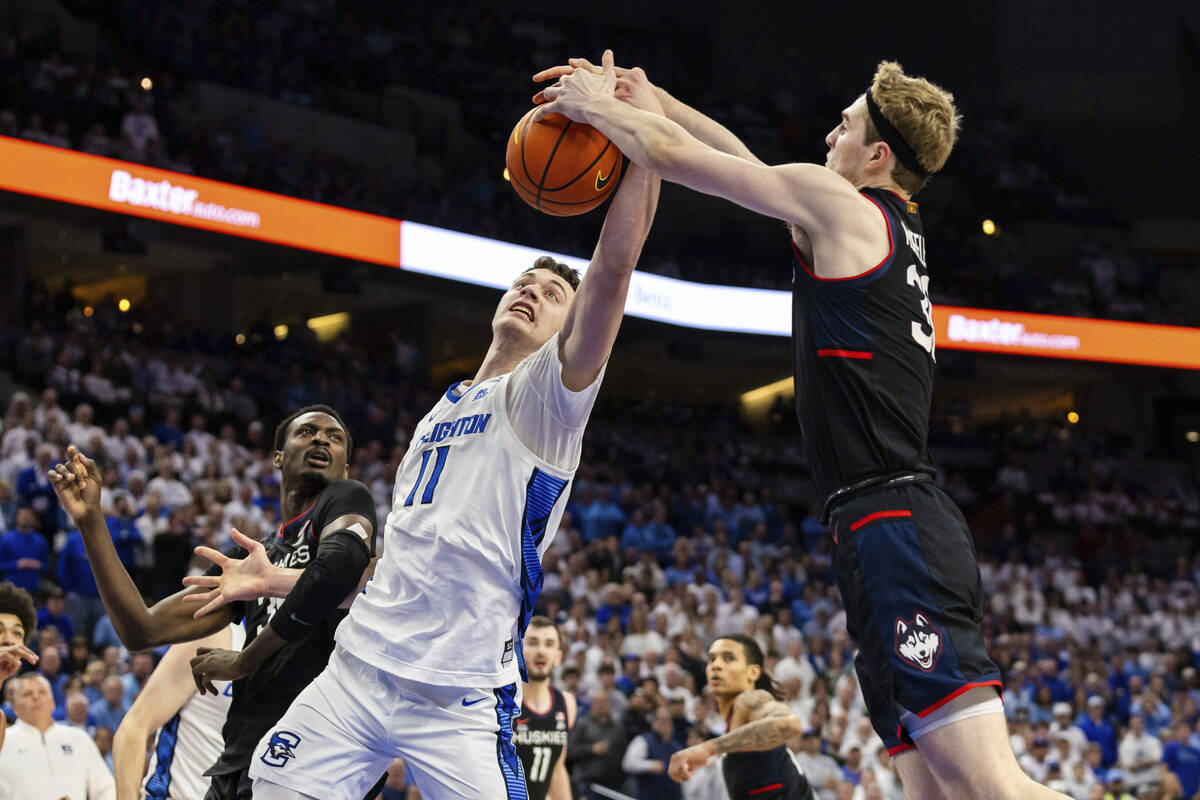 Creighton center Ryan Kalkbrenner (11) reaches for a rebound against UConn forward Liam McNeele ...