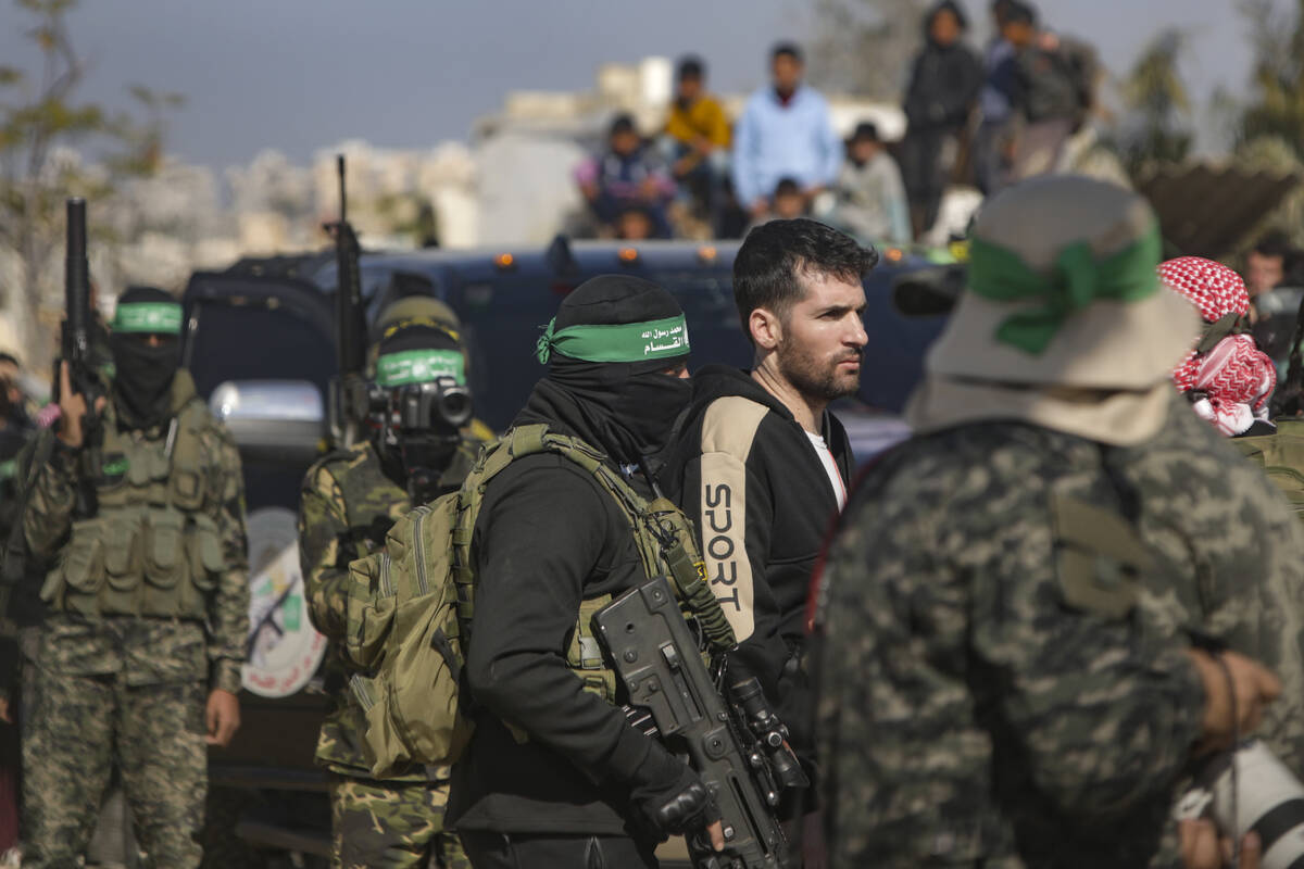 American-Israeli captive Sagui Dekel Chen, 36, is escorted by Hamas fighters as he is handed ov ...