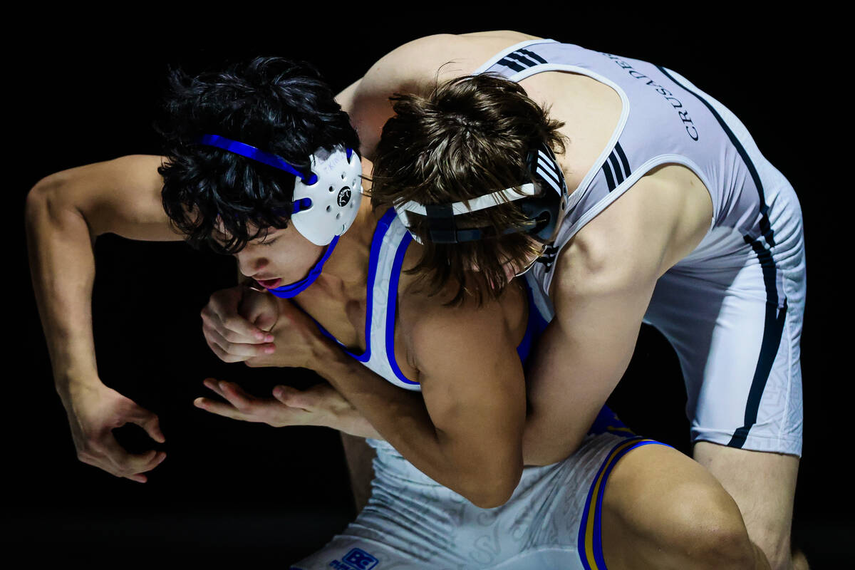 Faith Lutheran wrestler Cayden Cook keeps on top of Sierra vista wrestler Renz Songia during th ...