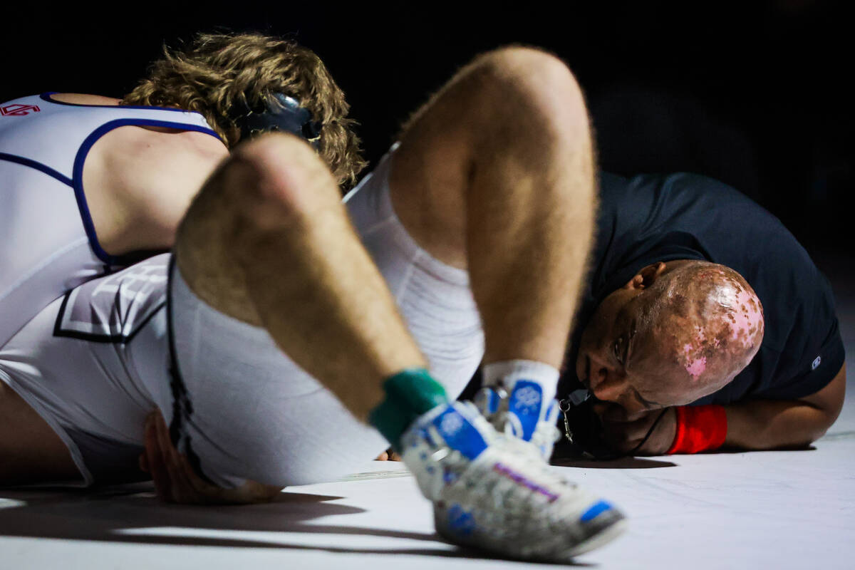 A referee watches action during the 4A state wrestling meet at Western High School Saturday, Fe ...