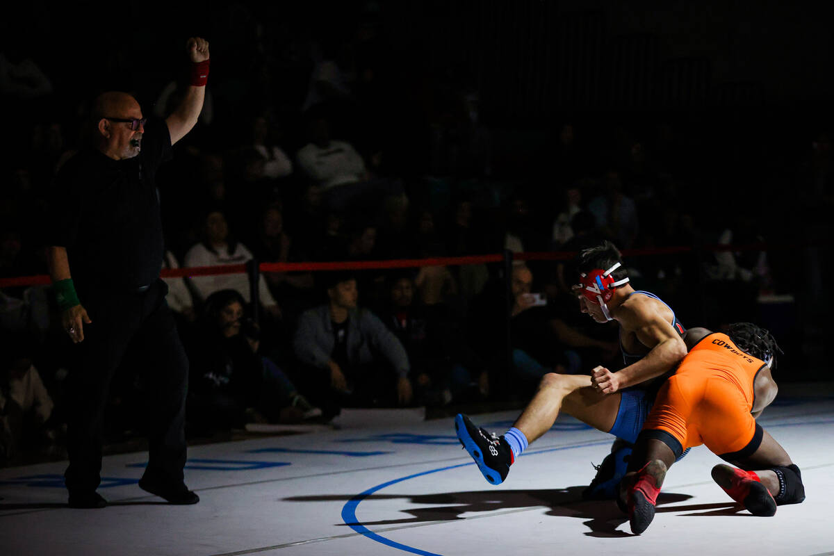 A referee signals as Western wrestler Wade Alcantar, middle, and Chaparral wrestler Isiah Kayee ...