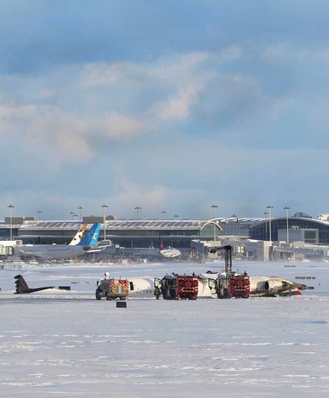 An aircraft from Delta Airlines sits upside down on the tarmac at Toronto Pearson International ...