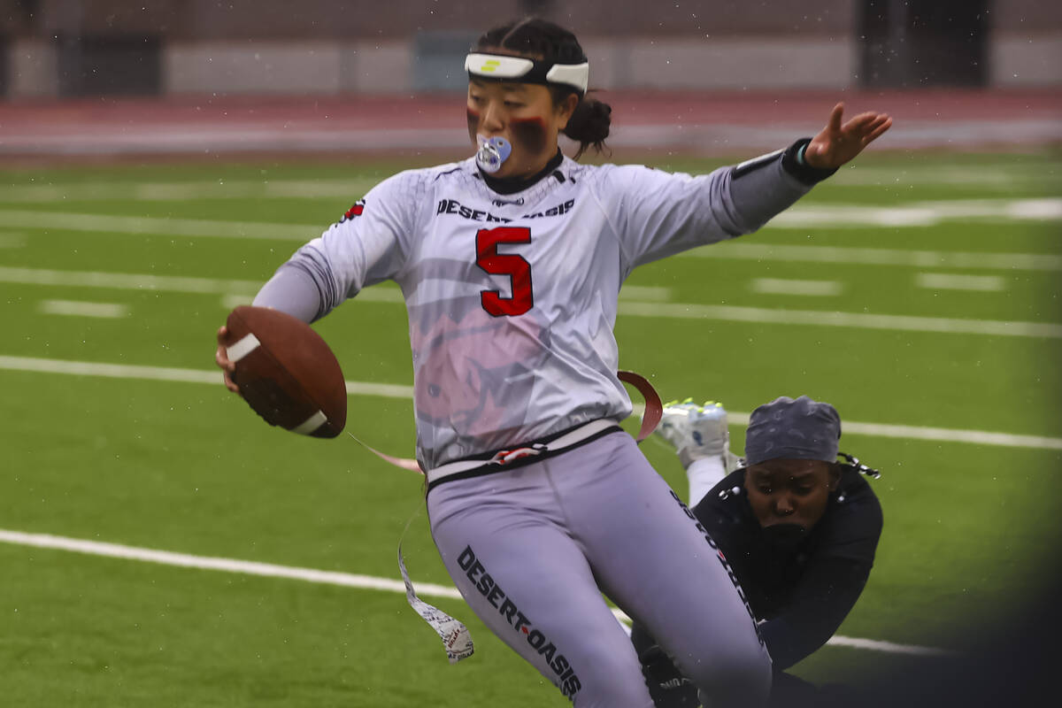 Desert Oasis quarterback Akemi Higa (5) dodges a Shadow Ridge defender while running the ball d ...