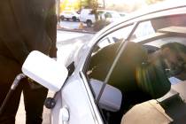 Mohamed Alomari is reflected on his car window as he pumps gas at Rebel gas station on Tropican ...