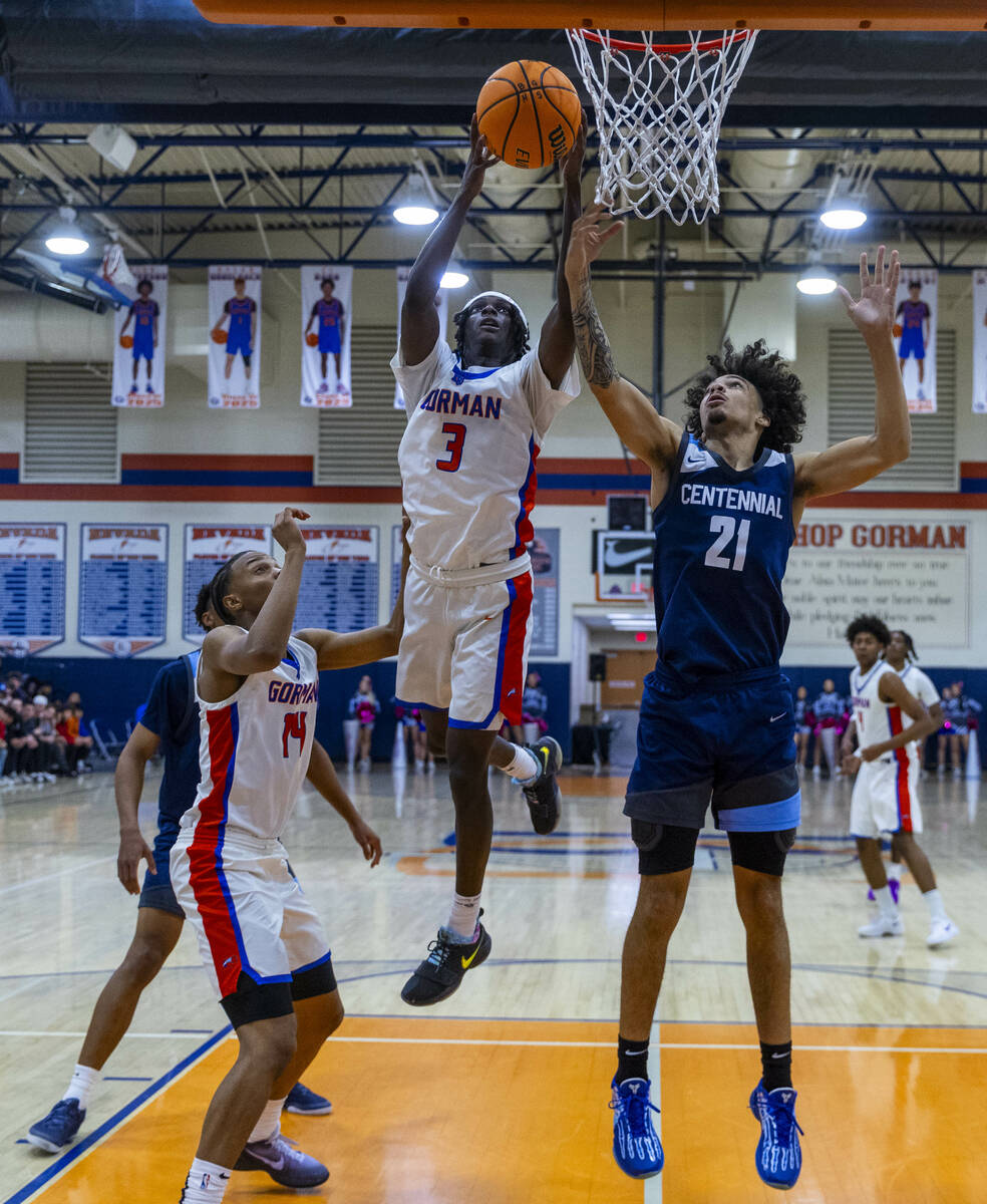 Bishop Gorman's Ty Johnson (3) elevates past Centennial's Jaylen Kelly (21) for a basket during ...