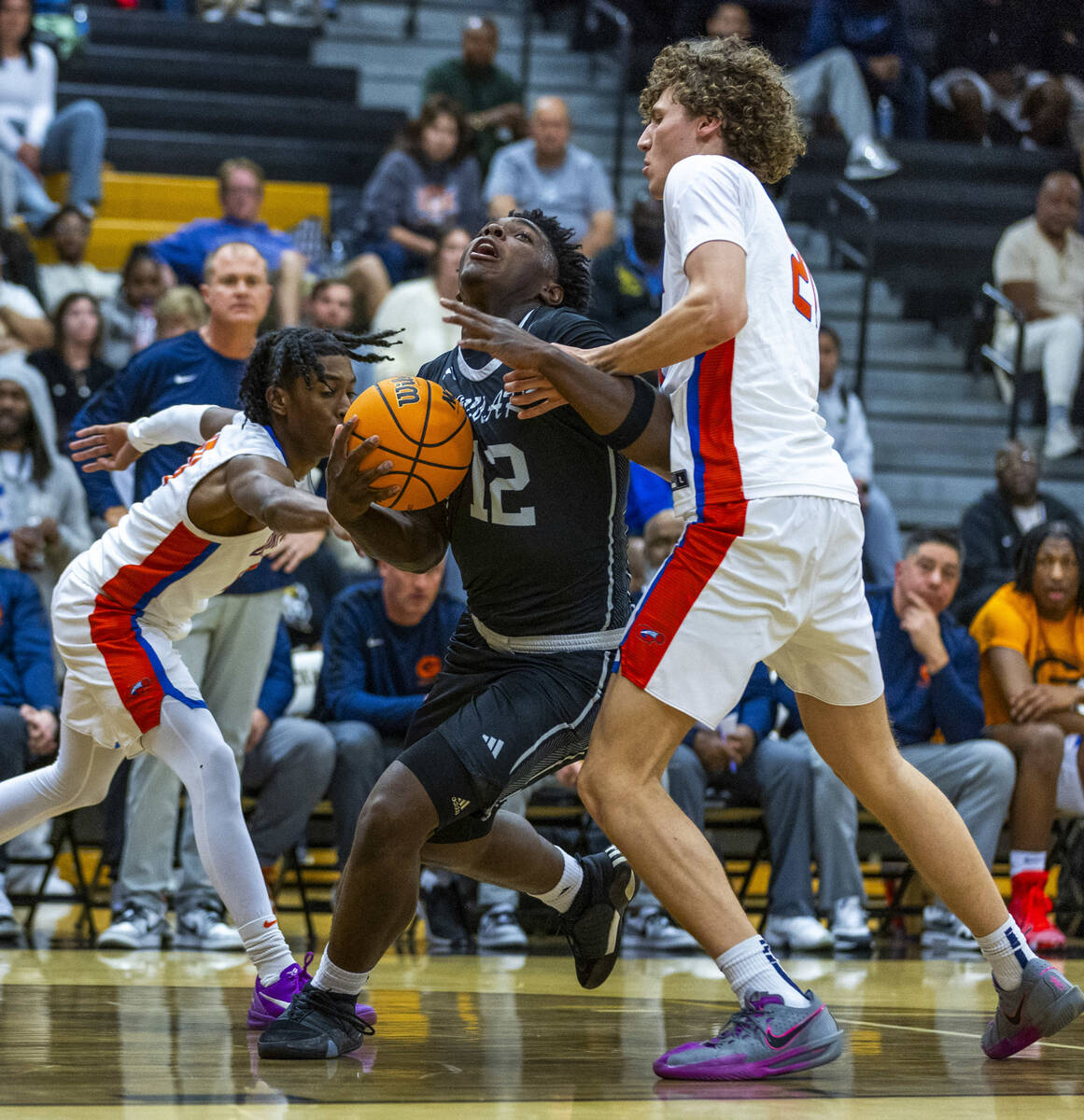 Desert Pines forward Mike Taylor (12) is fouled on a drive by Bishop Gorman center Chris Baudre ...