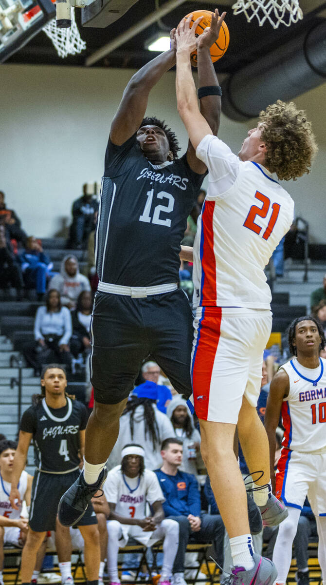 Desert Pines forward Mike Taylor (12) is fouled on a shot by Bishop Gorman center Chris Baudrea ...
