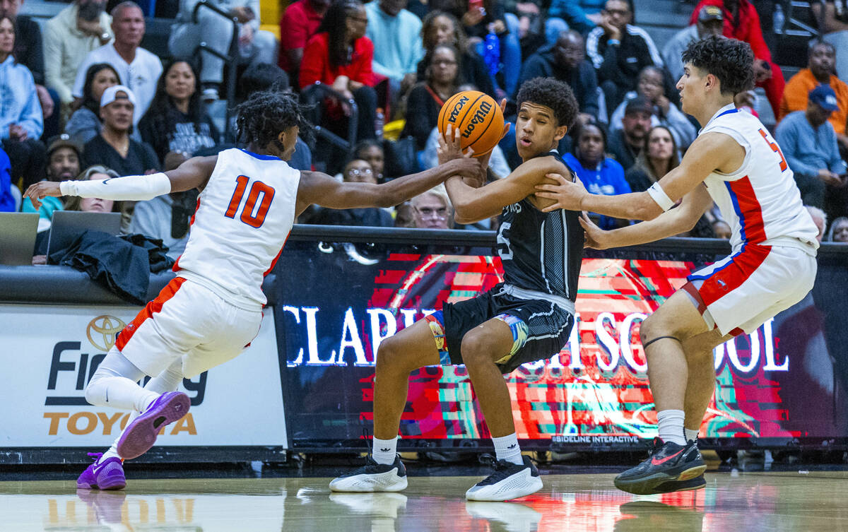 Bishop Gorman guard Nick Jefferson (10) grabs the arm of Desert Pines guard Mason Robles (5) as ...
