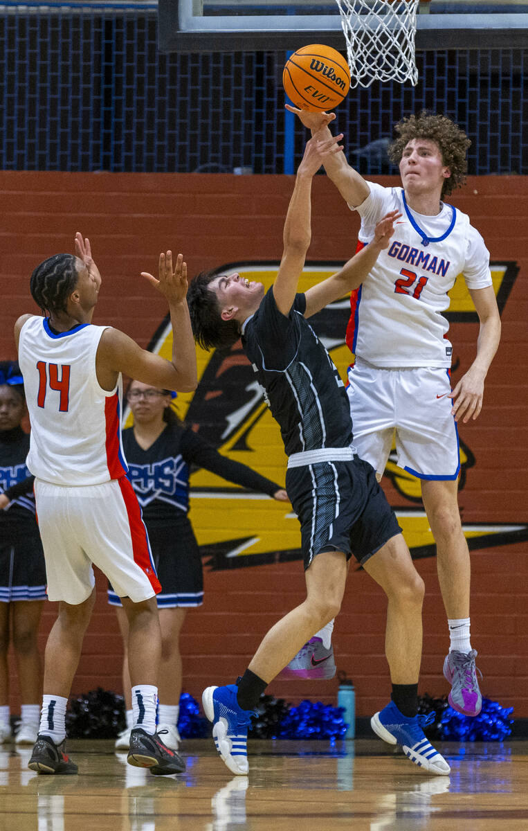 Bishop Gorman center Chris Baudreau (21) rejects shot attempt by Desert Pines guard Mason Roble ...