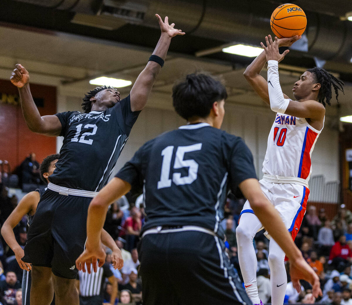 Desert Pines forward Mike Taylor (12) arrives late to block shot by Bishop Gorman guard Nick Je ...