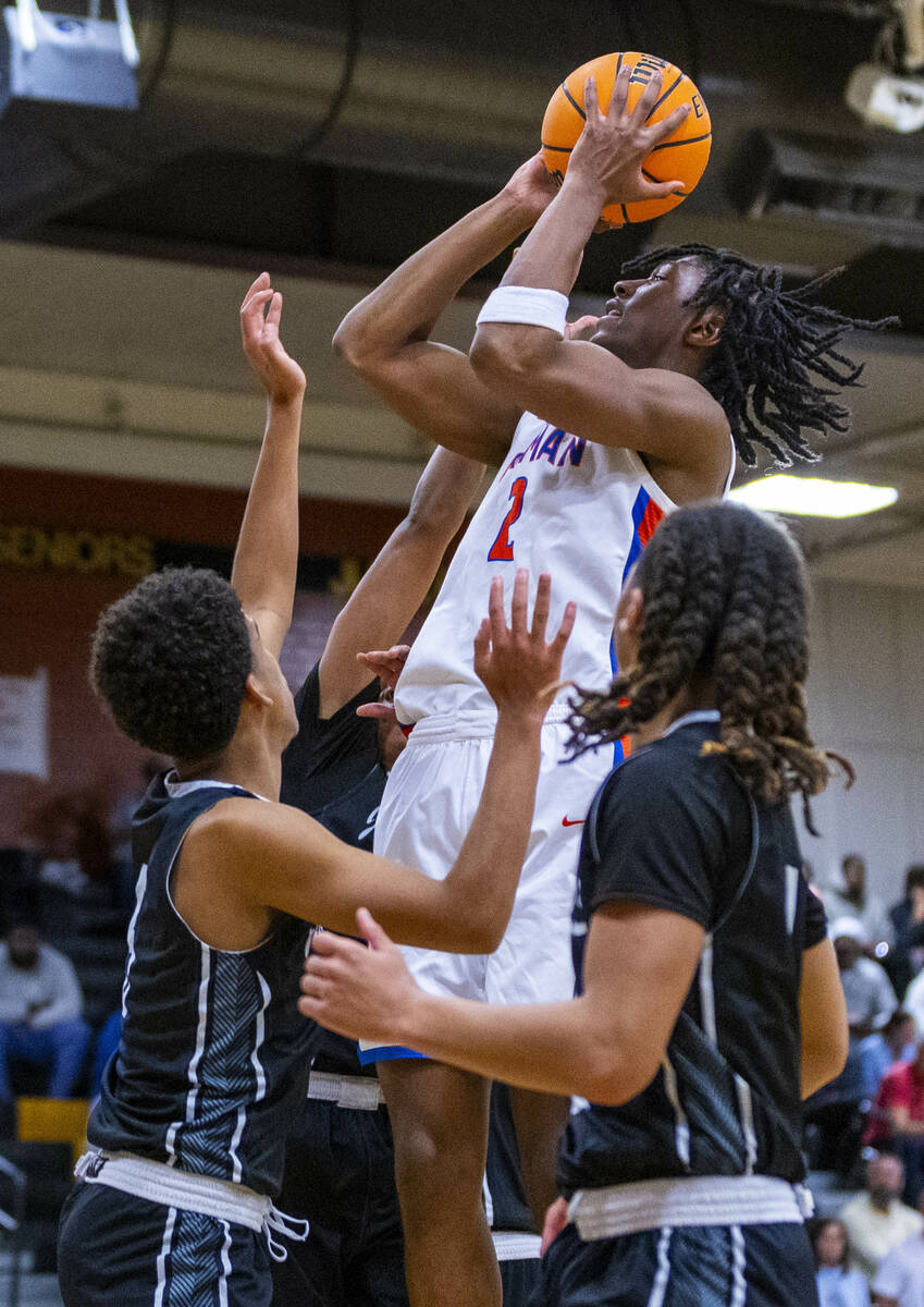 Bishop Gorman forward Jett Washington (2) elevates for a score past Desert Pines guard Mario Fl ...