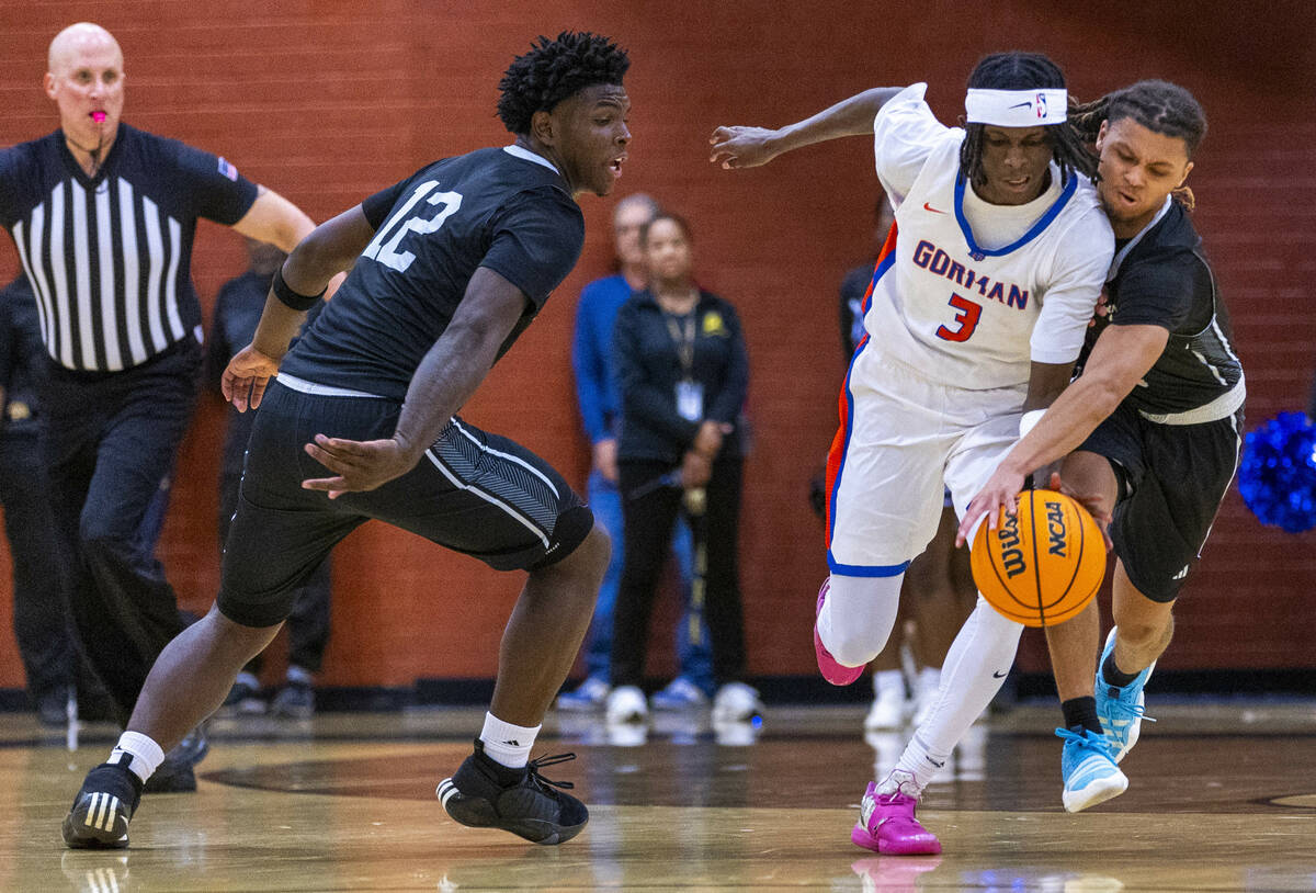 Bishop Gorman guard Ty Johnson (3) is fouled by Desert Pines guard Prince Davis (4) as forward ...