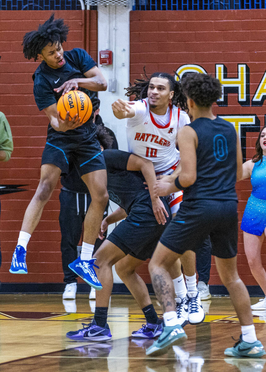 Silverado guard Jaden Charles (4) pulls down a rebound past Mojave forward Isaiah Trotter (10) ...