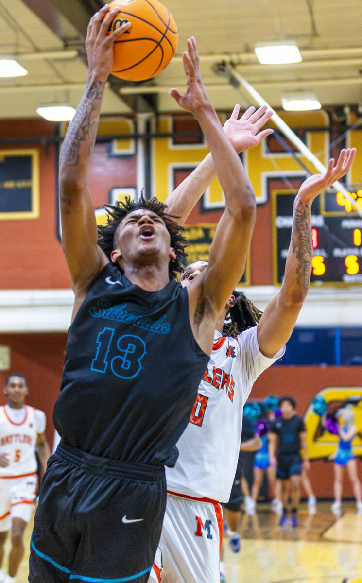 Silverado forward Travis Fralin (13) gats past Mojave forward Isaiah Trotter (10) fora basket d ...