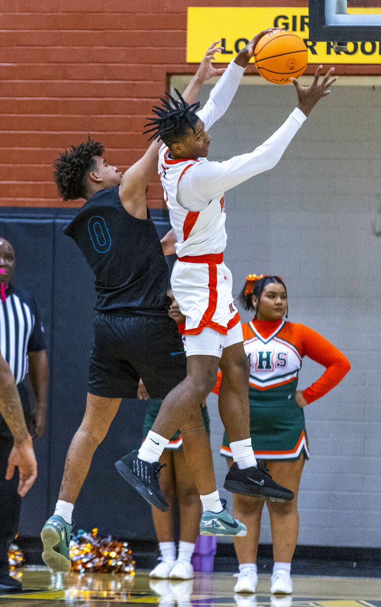 Mojave guard Zacarrion Jackson (1) pulls down a rebound over Silverado guard Kayden Goss (0) du ...