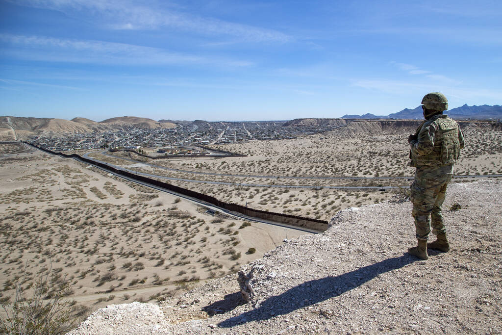 An Army soldier looks at the border wall while providing security to the visit of Defense Secre ...