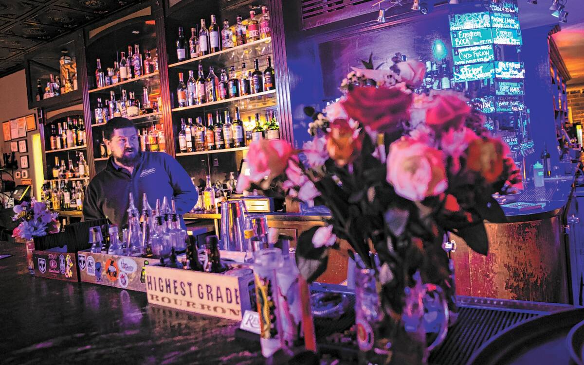 Andrew Mendez, general manager of Atomic Liquors, checks on the bar area as floral arrangements ...