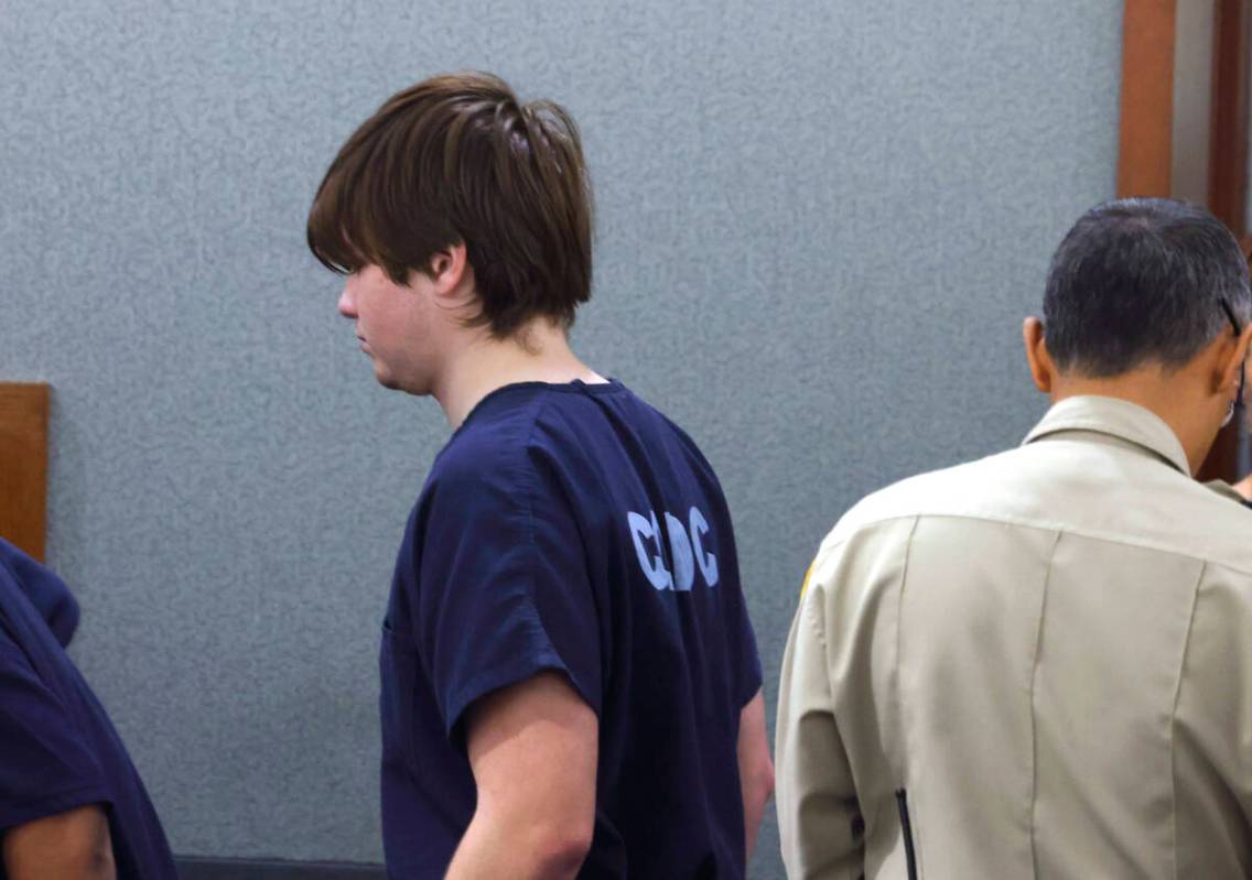 Joshua Martinez, 19, accused of killing a man found dead outside of a Walgreens, is led into a ...