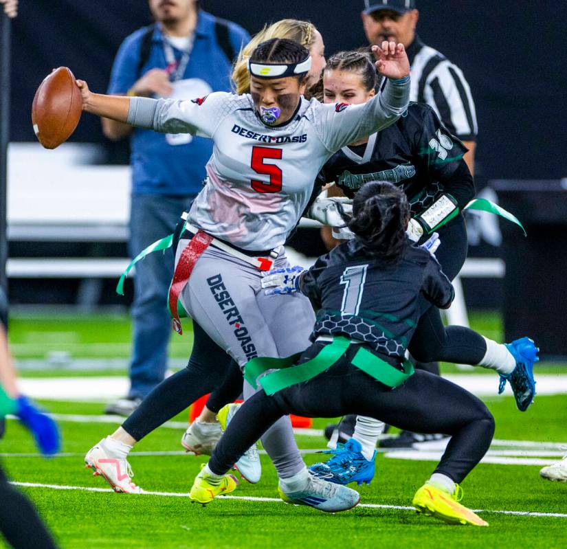 Desert Oasis quarterback Akemi Higa (5) looks to evade a flag pull by Palo Verde linebacker Mak ...
