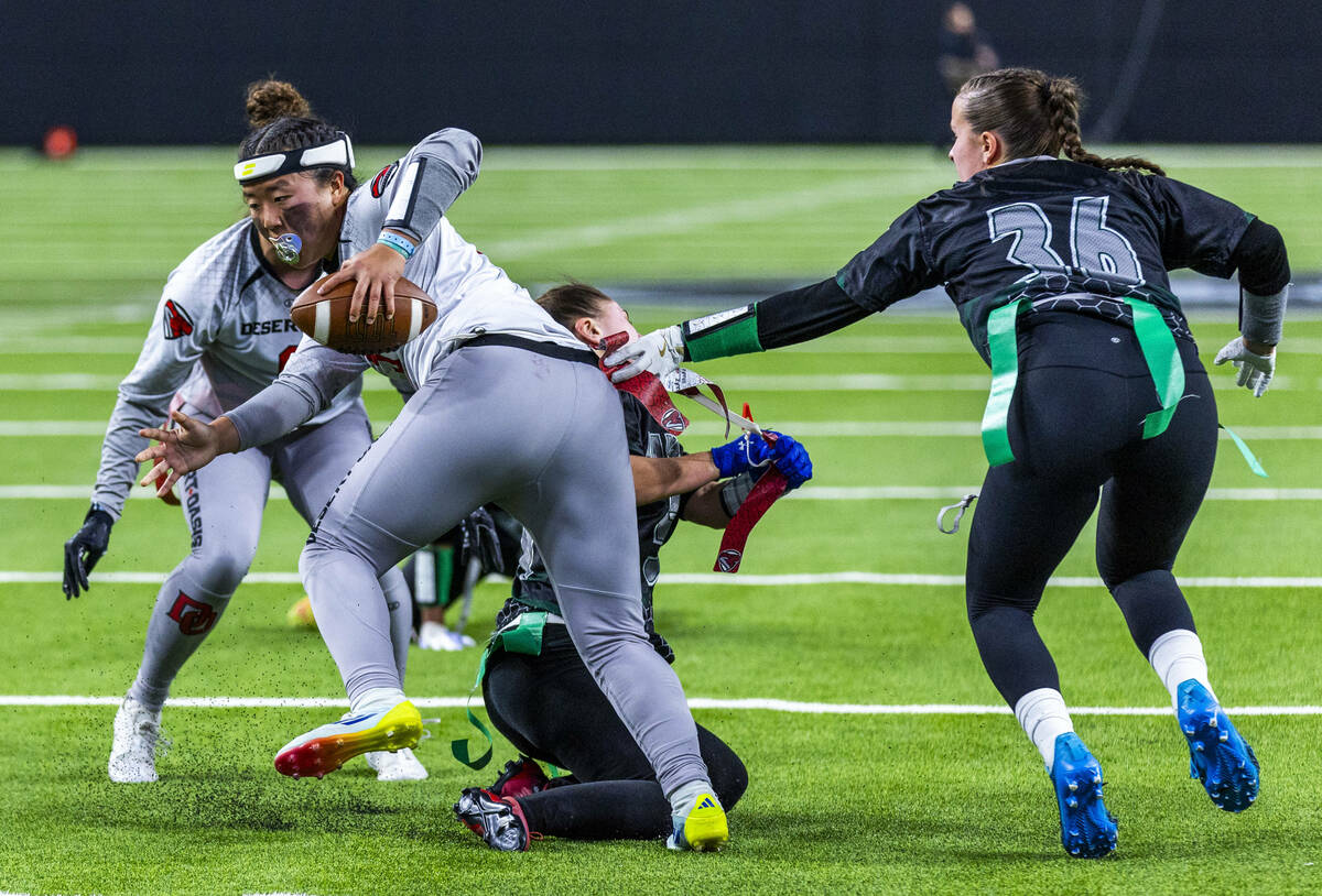 Desert Oasis quarterback Akemi Higa (5) has he4r flags pulled on a run by Palo Verde linebacker ...