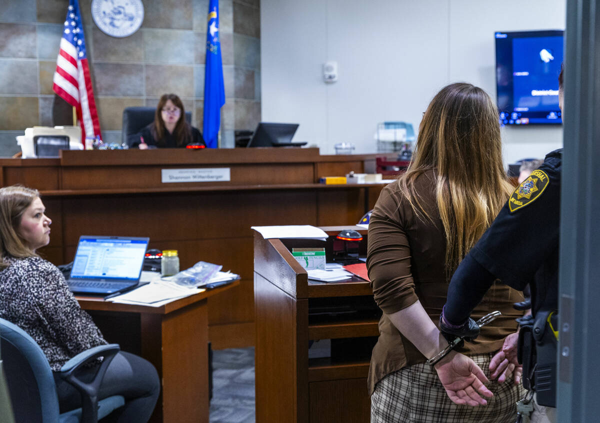 A participant is detained for a violation as Hearing Master Shannon Wittenberger speaks to her ...