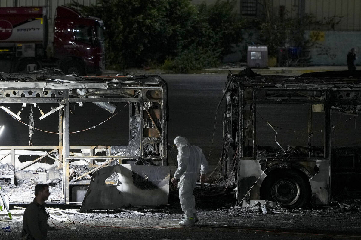 Israeli police inspect the scene of one of a series of bus explosions in what authorities said ...