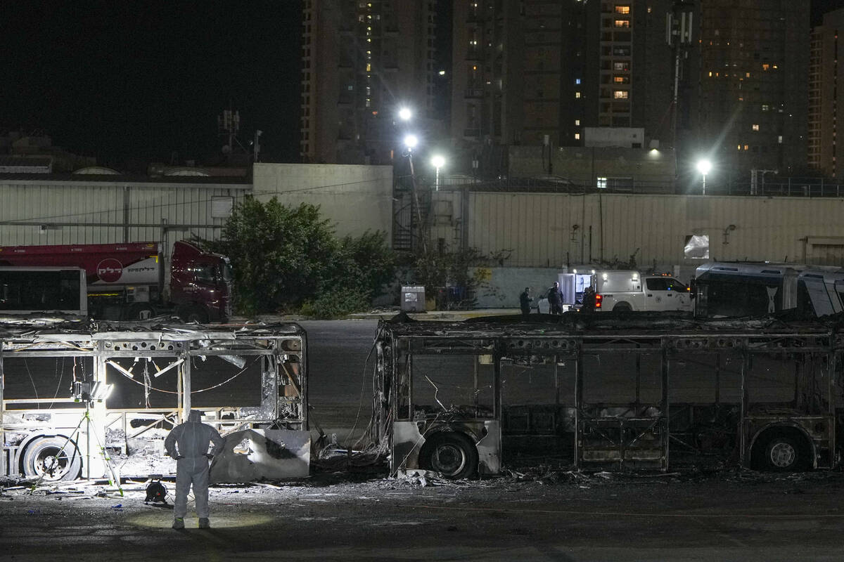 Israeli police inspect the scene of one of a series of bus explosions in what authorities said ...