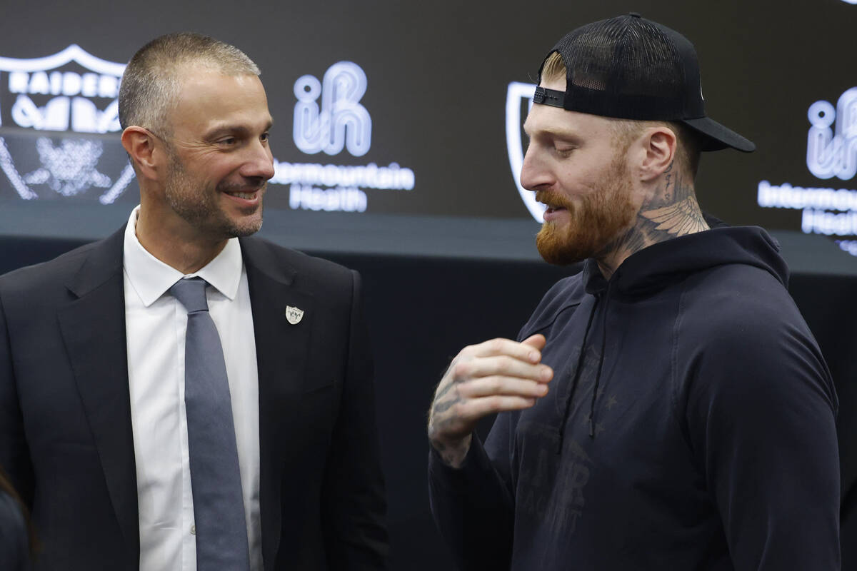 The new Raiders general manager John Spytek, left, chats with defensive end Maxx Crosby after a ...