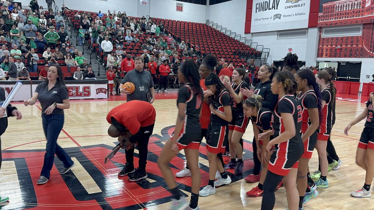 Mater East girls basketball coach Oscar Davis celebrates with the state championship trophy aft ...