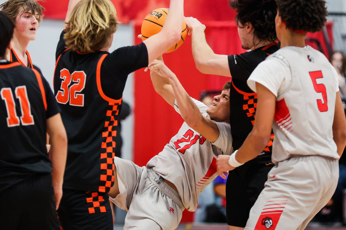 Mater East guard Deven Taylor (21) falls as he attempts a shot during a class 3A boys basketbal ...