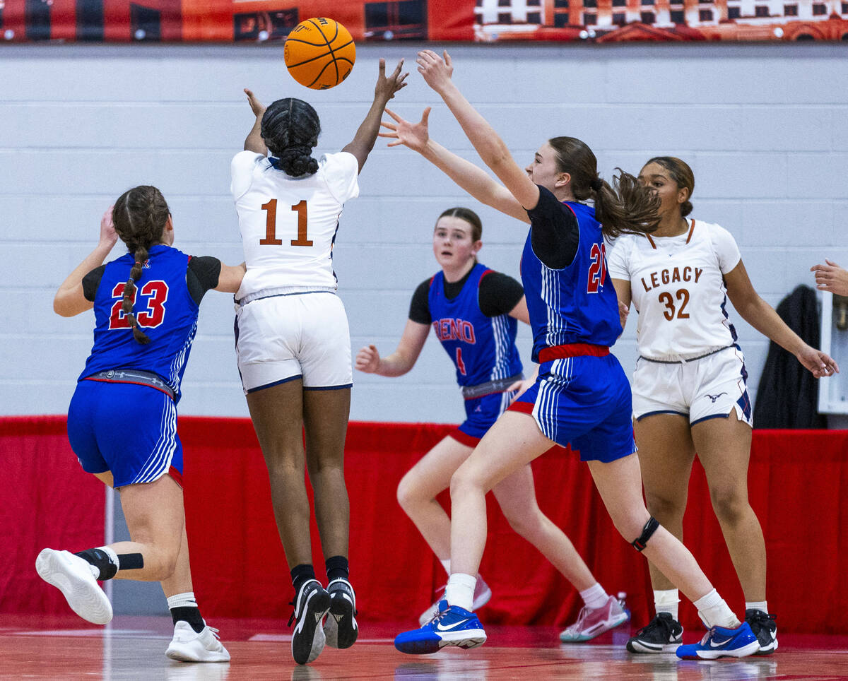 Legacy guard Deshaya Hart (11) and Reno forward Eva Houston (20) reach for a loose ball during ...