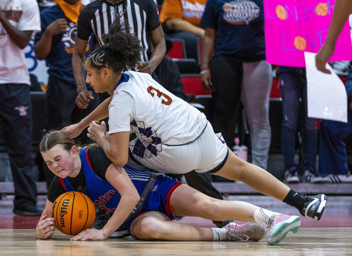 Reno guard Brookesly Wilson (4) has Legacy guard Laila Gines (3) land atop her as they battles ...