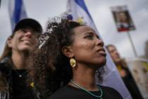 A woman reacts as the first two of six hostages to be released in Gaza by Palestinian militants ...