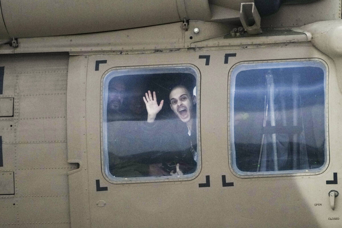 Freed Israeli hostage Omer Wenkert, gestures from a military helicopter as he arrives at Beilin ...