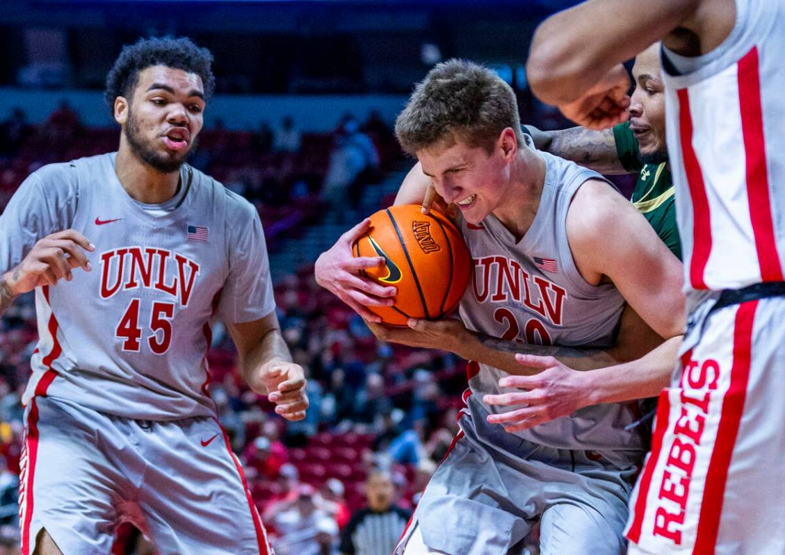 UNLV guard Julian Rishwain (20) is fouled from behind by Colorado State Rams forward Rashaan Mb ...