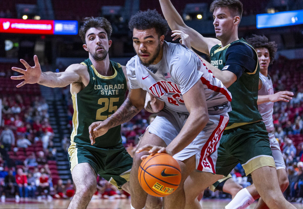UNLV forward Jeremiah Cherry (45) looks for an opening to shoot while double teamed by Colorado ...