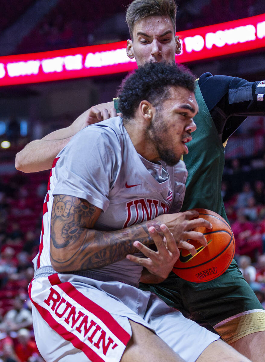 UNLV forward Jeremiah Cherry (45) collides underneath the basket with Colorado State Rams cente ...