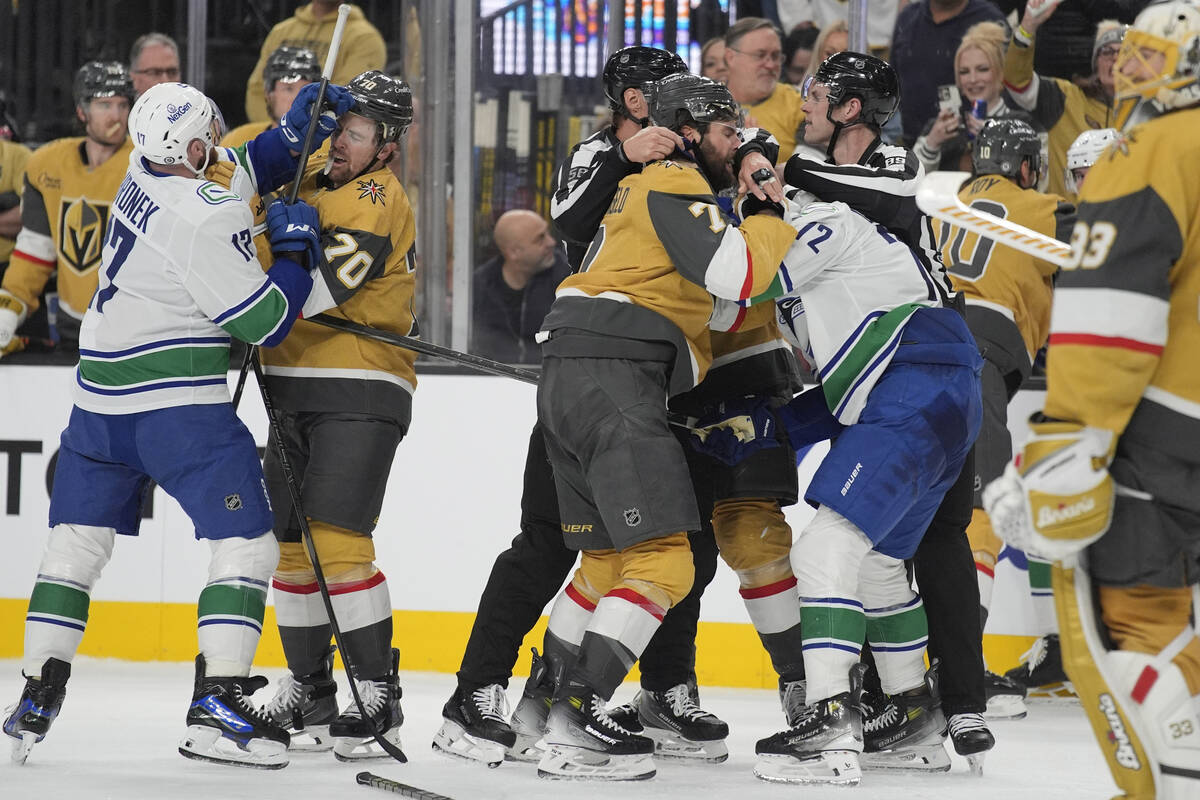Vegas Golden Knights and Vancouver Canucks players scuffle during the third period of an NHL ho ...