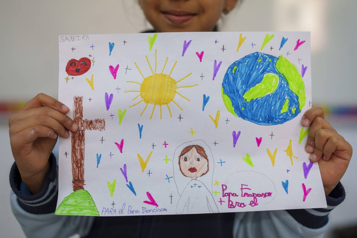 Samira, 8, shows s a picture reading in Spanish: "For the Pope Francisco" as part of ...