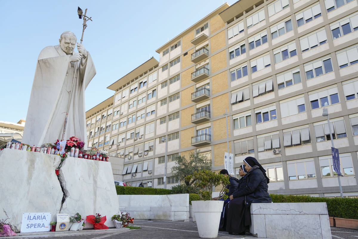 Nuns pray in front of the statue of late Pope John II outside the Agostino Gemelli Polyclinic w ...