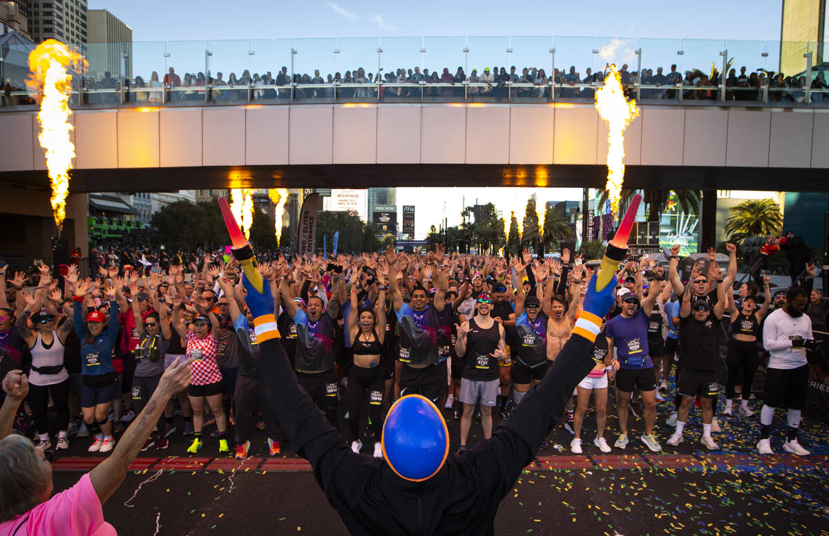 Members of the Blue Man Group interact with race participants as they take off from the start l ...